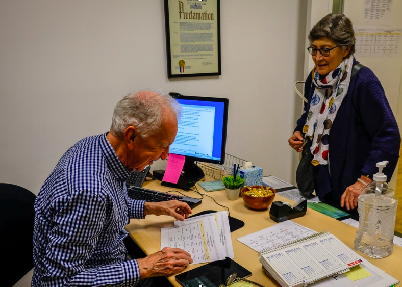 IRP member Michael Hill helping member Rita Silverman at the First Desk in the IRP’s office, 2018