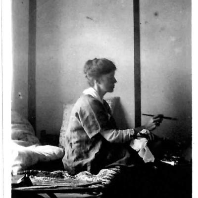 Black and white photo of a woman painting.