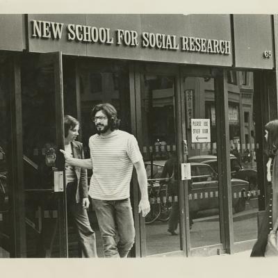 A man leaving a building labeled New School for Social Research.